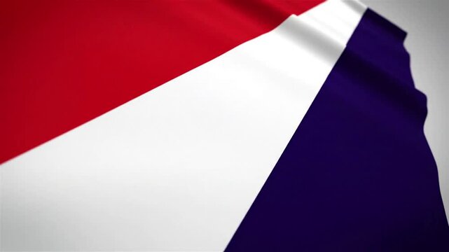 A close-up view of a waving flag with red, white, and blue stripes, showing dynamic folds and shadows.