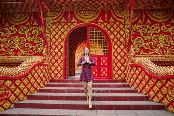 A Serene Moment of Reflection and Gratitude in a Vibrant Temple Setting Surrounded by Rich Colors and Intricate Patterns