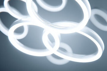 A futuristic minimal white scene with multiple glowing rings floating, background softly blurred.