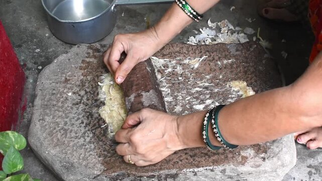 Indian village lage using grinding stone or sil batta for making masala, grinding garlic making paste. it is a traditional method that is still used in some part of the country.	