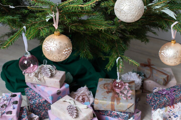 Vibrant pink and purple gift boxes with shiny ribbons rest under a Christmas tree adorned with glowing lights, creating a playful and joyful festive scene