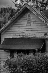 Obraz premium Old Abandoned House with an Attic and a Steep Roof in Black and White.