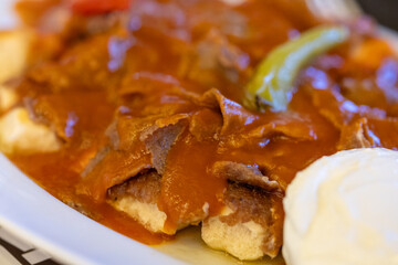 Close-Up of Turkish Iskender Kebab with Doner Meat on a White Plate

