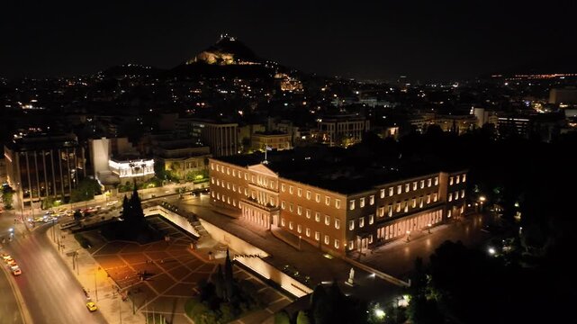 Aerial drone cinematic night video from famous illuminated Syntagma square and Greek Parliament  building, Athens historic centre, Attica, Greece