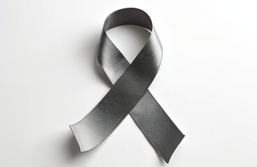A gray ribbon symbolizes brain cancer awareness. This photo features a studio shot with a satin ribbon. The symbol sits on a white backdrop. It represents support for those affected by brain cancer.