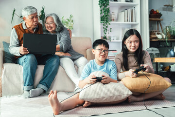 Happy Asian Family Gathering in Cozy Living Room with Grandparents and Children Laughing, Playing, and Sharing Fun Moments Together in Warm Domestic Atmosphere