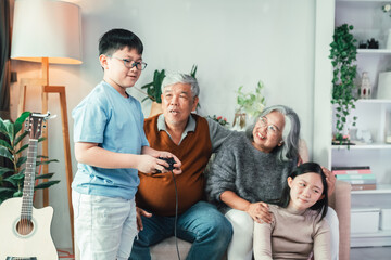 Happy Asian Family Gathering in Cozy Living Room with Grandparents and Children Laughing, Playing, and Sharing Fun Moments Together in Warm Domestic Atmosphere