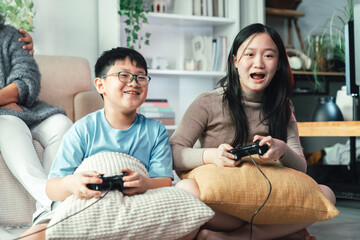 Asian Children Playing Video Game Console at Home Living Room Creating Joyful Family Bonding, Childhood Entertainment, Technology Interaction, and Happy Togetherness