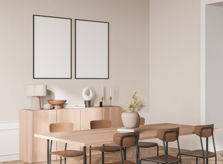 Contemporary interior scene with two blank framed posters on beige wall above light wood sideboard and dining set, minimalist layout concept. 3D Rendering