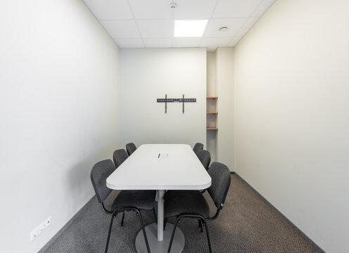 Modern Small Conference Room with Table and Chairs in Minimalist Design. 