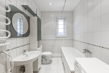 Clean and modern bathroom interior with bathtub, toilet, and sink. 