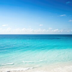 Fototapeta premium Crystal clear turquoise ocean water meeting a white sandy beach under a bright blue sky