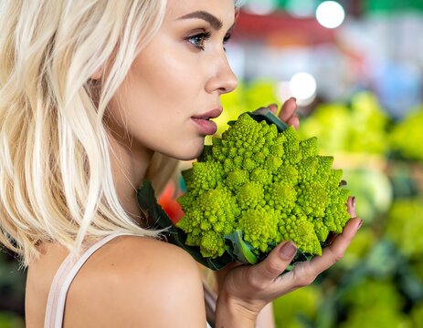 Woman holding Romanesco broccoli in market