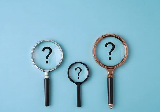 Three magnifying glasses with question marks on a light blue background in a studio shot
