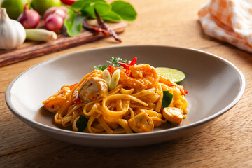 Creamy Fettuccine pasta Tom Yum Kung,Thai style fusion food, spicy spaghetti with shrimp and straw mushroom in tom yum sauce.