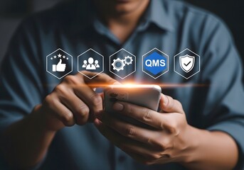 Man using smartphone with quality management system icons hovering above the device in a modern setting