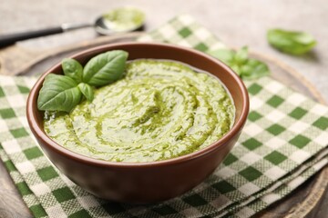Fresh pesto sauce with basil leaves in bowl on table, closeup