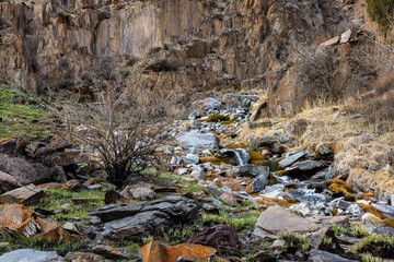 Serene stream flowing through rocky terrain in mountainous region of Kyrgyzstan at sringtime