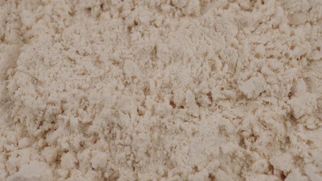 Close-up of vanilla protein powder. Rotating textured background. Sports nutrition supplement for fitness, healthy diet, muscle gain and workout recovery concept. White protein, whey powder
