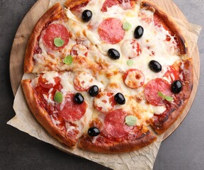 Delicious pizza with cheese, salami and olives on grey table, top view