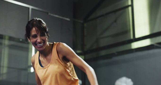 Padel court, laugh and woman in competition, training and exercise for tournament challenge. Tennis, racket and mature player swing with ball for sports game, fitness or funny joke in indoor club