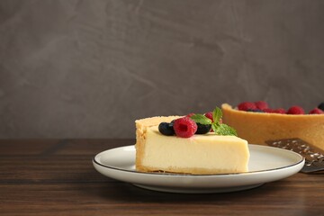 Delicious cheesecake with fresh berries and mint served on wooden table, space for text