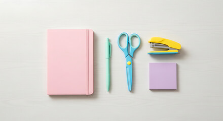 Overhead shot of a pink notebook, mint pen, blue scissors, yellow stapler, and purple sticky notes arranged neatly on a white wooden surface, creating a clean and organized aesthetic isolated on white