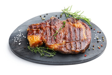 Delicious grilled beef steak with herbs and spices isolated on white