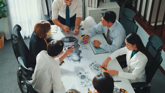 Group of diverse team planning strategy while sitting at table with project plan. Top aerial view of smart business people working together to brainstorm and design house construction. Alimentation. - Powered by Adobe