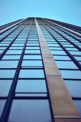 Modern glass skyscraper reaching toward clear blue sky