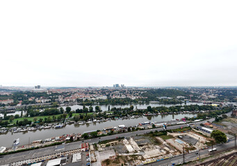 Fototapeta premium Aerial river panorama with islands and embankments, industrial waterfront and construction area in foreground, wide urban landscape showing infrastructure and nature balance concept.