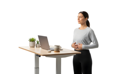 Woman practicing mindfulness while standing at a desk with a laptop, performing a breathing exercise