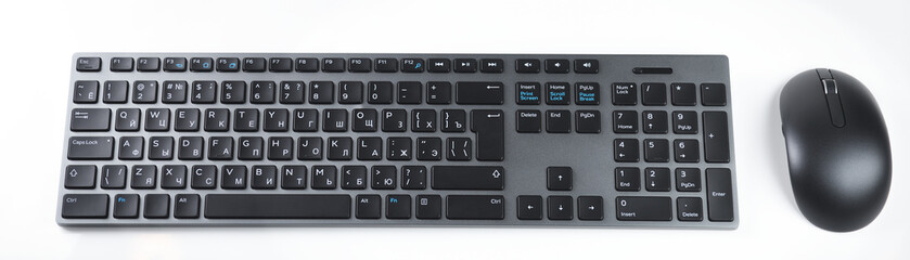 Black computer keyboard with mouse with modern layout for typing on white background.