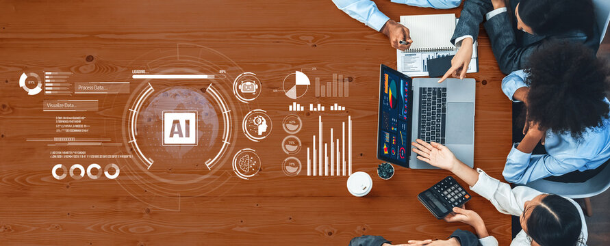 A diverse business team demonstrates collaboration in a modern office, analyzing artificial intelligence data using graphs and visuals on laptops to enhance productivity. Trope - Powered by Adobe