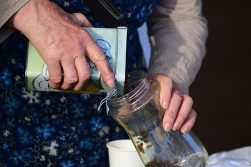 La femme versant des grains de caf&eacute; dans un bocal