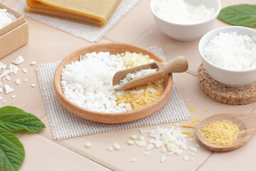 Variety of emulsifiers in clay bowl with cosmetic ingredients and mix of wax