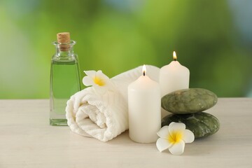 Beautiful spa composition with burning candles on white wooden table against blurred background, closeup