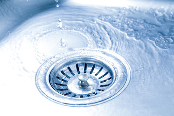 Water going down sink drain, closeup view