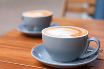 Cups of aromatic coffee on wooden table, closeup