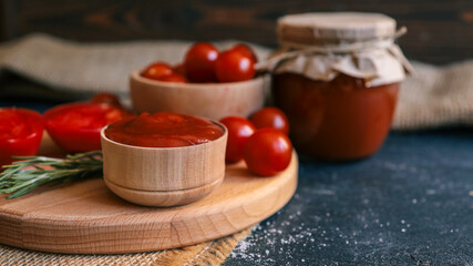 Tomato sauce and fresh tomatoes on a wooden board