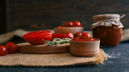 Fresh tomatoes and tomato sauce ingredients on a rustic wooden table.