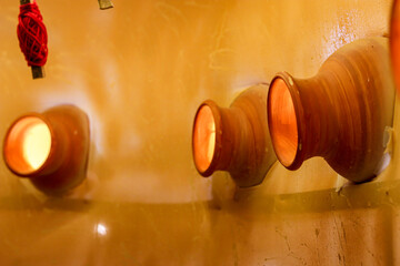 Golden Clay Pots Wall Decor: Traditional Terracotta Earthenware with Warm Ambient Lighting