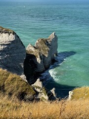 Cliffs of Étretat in Normandy, France during daytime, with natural rock arch and sea view framed...