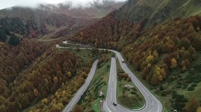 Winding mountain road through autumn forest with overhead perspective