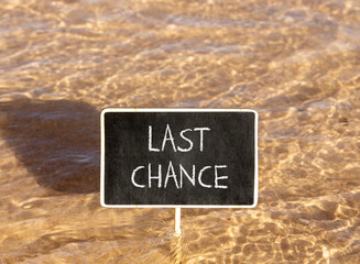 Naklejka premium Last chance symbol. Concept word Last chance on beautiful black blackboard. Beautiful Red sea water background. Black blackboard. Business last chance concept. Copy space.