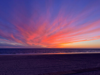 Farbenpr&auml;chtiger Sonnenuntergang am Strand von Andalusien mit intensiv leuchtendem Himmel in Violett, Rosa und Orange &uuml;ber dem ruhigen Meer &ndash; stimmungsvolle Abendaufnahme.