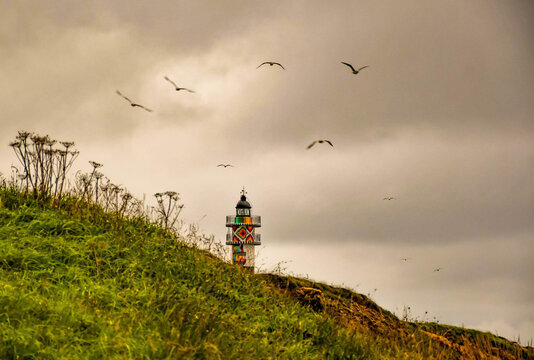 Ajo lighthouse, surrounded by flying seagulls.