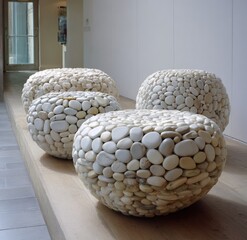 Four round, stone-covered stools create a tranquil focal point in a modern interior space.