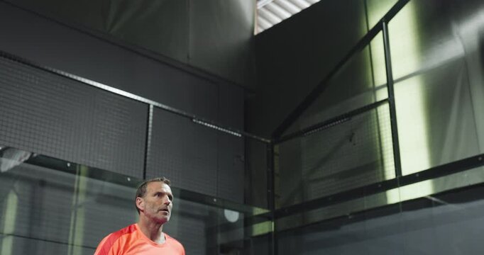Padel, fitness and mature man on court for training, match and practice game in sports club. Tennis, exercise and male athlete with racket, ball and serve for challenge, tournament and competition.