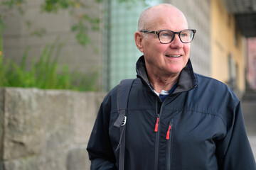 Portrait of a smiling senior man wearing sportswear in the city